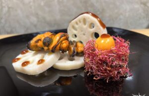 Radice di fiore di loto con spiedino di mitili e germogli di bietola rosa